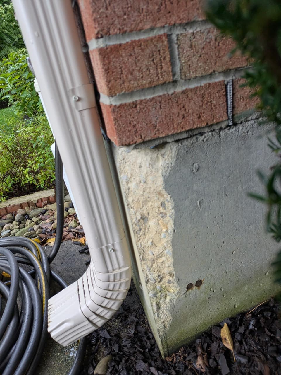 Deteriorated surface at an exterior foundation corner before repair